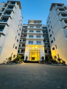 two large white buildings with a door in the middle at Soundproof 2 Bed apartment in Lahore Zameen Opal in Lahore