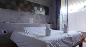 a bedroom with a white bed with two candles on it at K-1 Modern Art Hotel @ Nan in Nan +71 photos
