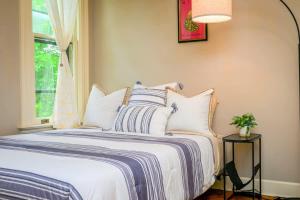 Un dormitorio con una cama con almohadas blancas y una ventana en Westcott 2BD Apt in Mansion mins SU & JMA Dome, en Syracuse