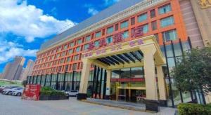 a large orange building with a sign in front of it at Cheerful Hotel in Nanhai
