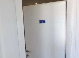 a white door with a blue sign on it at Apartments Ro Ma in Novo Selo Požeško
