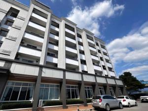 Ban Thung SuklaにあるLaemchabang City Hotelの大きな白い建物と駐車場に駐車された車