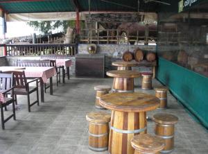 a restaurant with wooden stools and tables and chairs at Rooms Zeko in Aljmaš