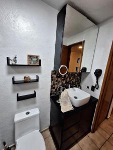 a bathroom with a sink and a toilet and a mirror at Casa Ana Victoria in Morelia +10 photos
