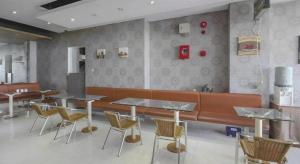 a restaurant with tables and chairs and a bench at Griya Jogja Hotel in Yogyakarta