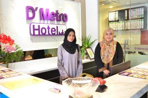 dos mujeres de pie en las mesas de una tienda en D'Metro Hotel, en Shah Alam