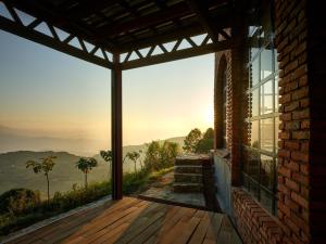 een kamer met uitzicht op de bergen door een raam bij Community Lodge Nepal - Chhimeki Lodge in Nagarkot