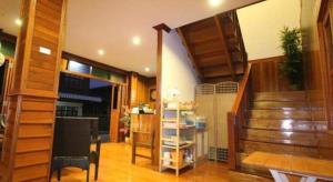 a living room with a staircase and a table and chairs at Ban Glai Kong in Chiang Khan +31 photos