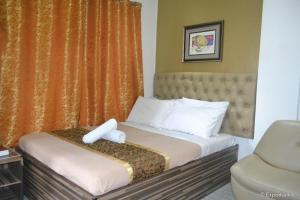 a hotel room with a bed and a chair at Zanrock Micro Hotel in Lagao III +71 photos