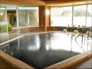 a swimming pool in a large room with windows at Yugawara Onsen Hotel Akane in Mongawa +52 photos