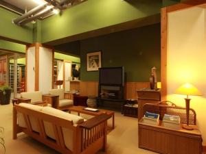 千国にあるOkanoue Hotel Miyagawaのソファとテレビのあるリビングルーム