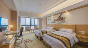 a hotel room with two beds and a television at Vienna International Hangzhou Future Science City in Hangzhou