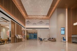 a lobby with a painting of mountains on the ceiling at MEHOOD LESTIE HOTEL- Changsha South Sation Branch in Changsha