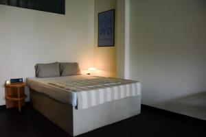 a bedroom with a bed with a lamp on it at Nova Surf House in Matara