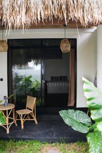 a patio with a table and chairs and a bed at Nova Surf House in Matara