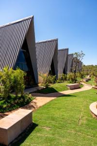 拉特纳吉里Dio Regaalo Theme Resort, Ratnagiri的一座带有折线屋顶和草坪的建筑物