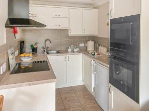 モリオンにある6 The Coveの白いキャビネットと黒い冷蔵庫のあるキッチン