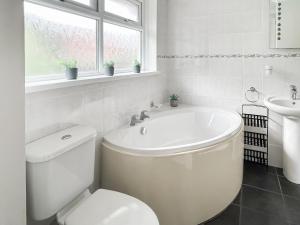 モリオンにある6 The Coveの浴槽、トイレ、洗面台を備えたバスルーム +4枚の写真