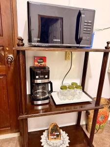 a microwave and a coffee maker and cups on a shelf at Apartamento - Casa Calderon, zona céntric in San Pedro Sula +3 photos