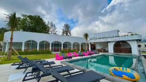 クブペンロカンにあるLushy Hostel Kintamaniのプールと椅子と建物のあるリゾート