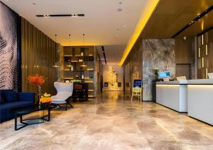 FujiatunにあるEcharm Hotel Aegean Shopping Park Zhonghuan Plazaのオフィスロビー(青いソファ、椅子付)