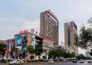 FujiatunにあるEcharm Hotel Aegean Shopping Park Zhonghuan Plazaの市道の高い建物2棟