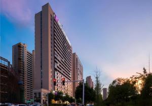 a tall building on a city street with a traffic light at Echarm Hotel Changsha High-speed Railway Station in Changsha