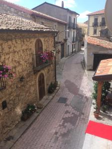 Une allée avec un bâtiment en pierre orné de fleurs dans l'établissement Hotel Sant'Anna, à Floresta