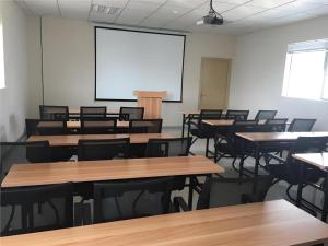 an empty classroom with tables and chairs and a screen at City Comfort Inn zhongshan Lihe Square Walmart in Zhongshan