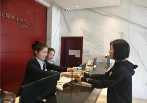 two women are shaking hands in an office at City Comfort Inn Yingcheng Railway Station Shanghe Square in Yingcheng