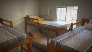 a room with three bunk beds and a window at Hostel Tiquinho in Belém