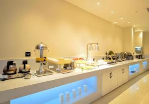 a large kitchen with a counter with food on it at City Comfort Inn Lichuan Railway Station Jimi Home in Datang