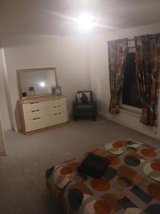 Un dormitorio con una cama, una cómoda y un espejo. en Grantham Town Centre, en Lincolnshire