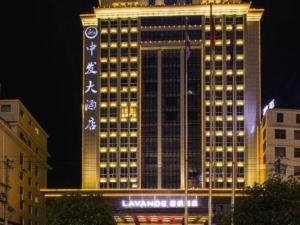 a tall building with lights on it at night at Lavande Hotels· Yueyang Linxiang Zhongfa in Linxiang