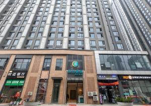 武漢市にあるCity Comfort Inn Wuhan International Expo Center Yongwangの窓が多い高層ビル