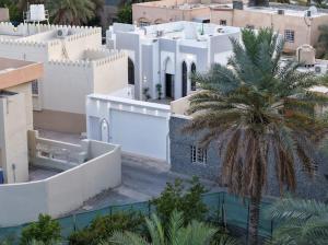 a palm tree in the middle of a city at Lateen Chalet - شاليه لتين in Nizwa
