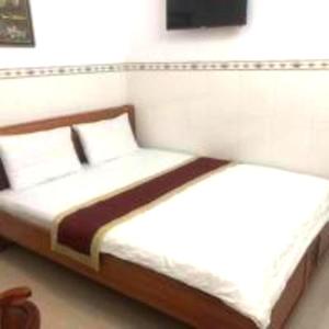 a bed with two pillows in a bedroom at Happy 1 Hotel Binh Duong in Bến Cát