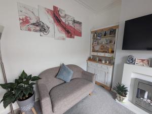 Una sala de estar con un sofá y un televisor. en Grantham Town Centre, en Lincolnshire