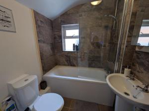 Un baño con bañera, inodoro y lavabo. en Grantham Town Centre, en Lincolnshire 6 fotos más