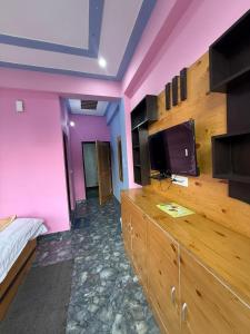 Un dormitorio con una cómoda grande y un televisor de pantalla plana. en Ruk bae cafe restro & hotel, en Mussoorie