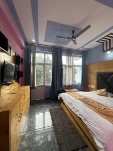 Un dormitorio con una cama grande y un ventilador de techo. en Ruk bae cafe restro & hotel, en Mussoorie 33 fotos más