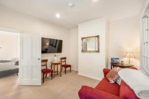 un salon avec un canapé rouge et une chambre dans l'établissement Hurst Cottage North Hobart x 6, à Hobart 16 autres photos