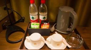 a tray with two cups and two bottles of soda at Borrman Hotel Huanggang Wuxue Yuhu Road in Wuxue