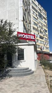 a building with a hostel sign in front of a tall building at Lighthouse in Aktau