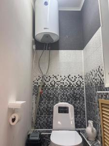 a bathroom with a white toilet and a black and white tiles at Lighthouse in Aktau