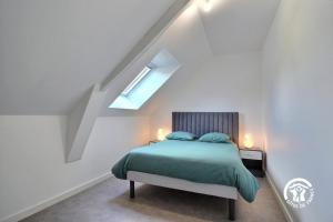 a bedroom with a green bed with a skylight at Longere du gaudin in Pluherlin