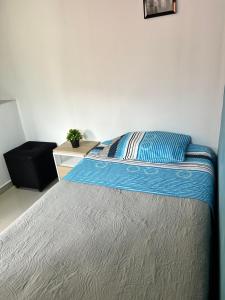 une chambre avec un lit recouvert d'une couette bleue dans l'établissement Tranquilo y bonito, à Bogotá 1 autre photo