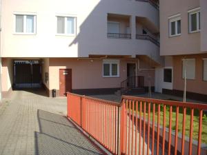 una valla naranja frente a un edificio en Margit Apartman, en Hajdúszoboszló