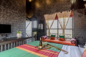 拉特纳吉里Dio Regaalo Theme Resort, Ratnagiri的一间设有一张床的客房,提供一瓶葡萄酒