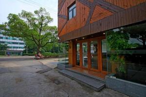 a building with a person on a scooter in front of it at Shell Hotel Shanghai Minhang District Wenjing Road Metro Station in Shanghai